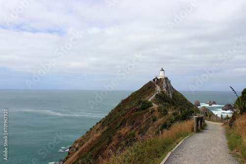New zealand rocks at the beach cliffs lighthouse on hill