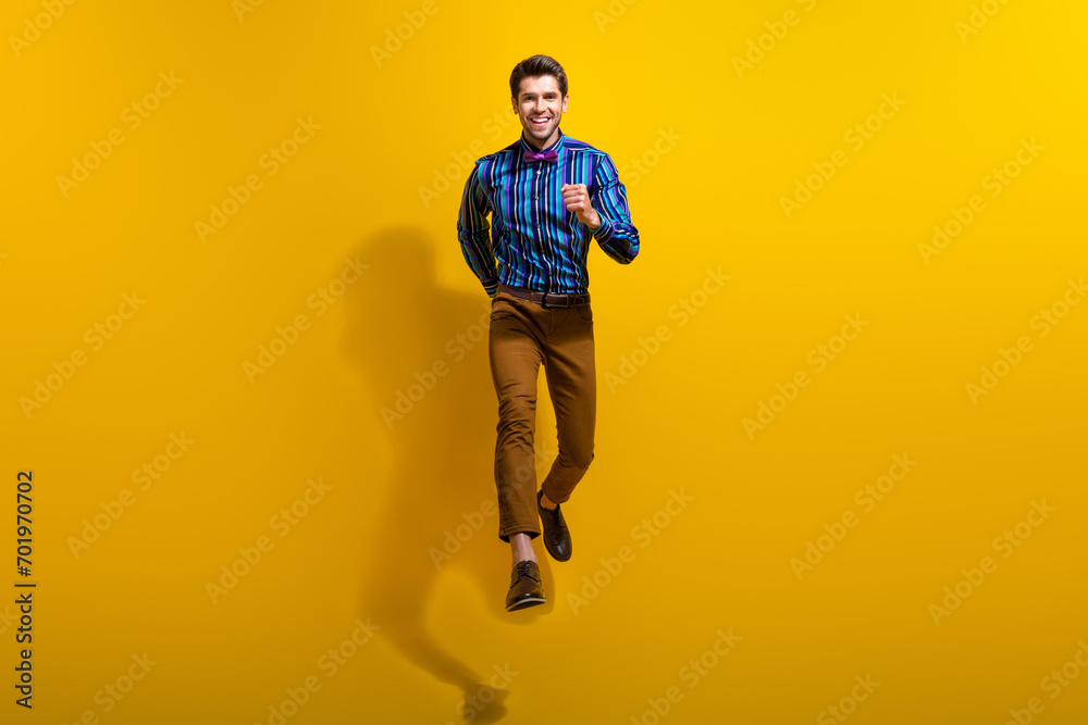 Full body photo of active energetic optimistic man wear bow tie stylish shirt hurry running shopping isolated on yellow color background
