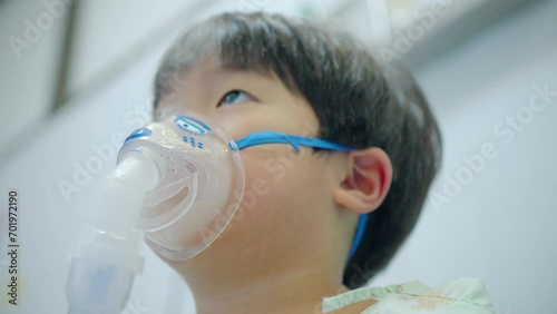 A little boy having a medicine inhalation with a nebulizer mask in the hospital.