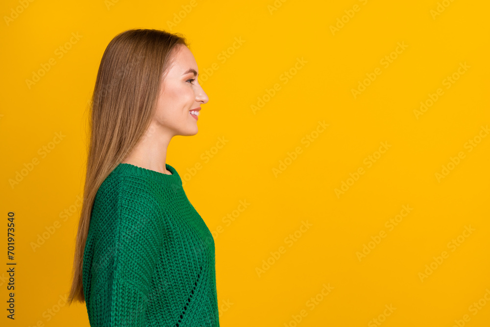 Profile side photo of friendly charming young woman wear green pullover looking empty space cheerful isolated on yellow color background Profile side photo of friendly charming young woman wear green pullover looking empty space cheerful isolated on yellow color background