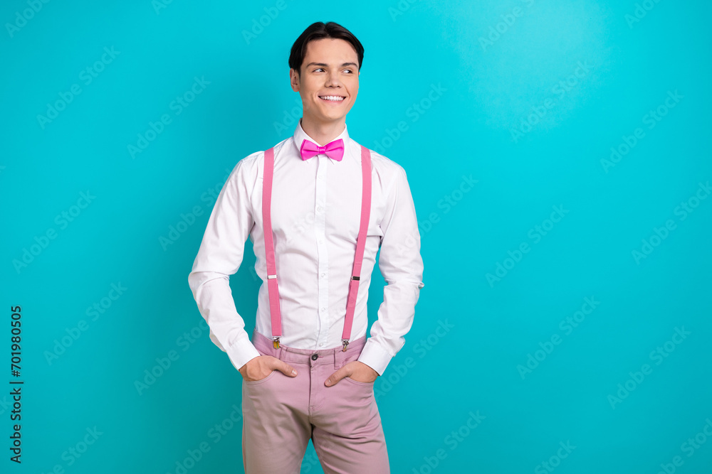 Photo portrait of attractive young man look empty space posing model wear trendy pink clothes isolated on cyan color background Photo portrait of attractive young man look empty space posing model wear trendy pink clothes isolated on cyan color background