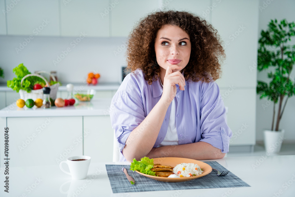 Photo of thoughtful pretty lady dressed purple shirt eating breakfast thinking day plans indoors house kitchen