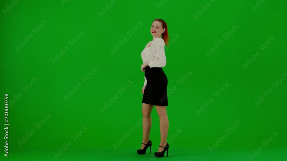 Portrait of attractive office girl on chroma key green screen. Woman in skirt and blouse posing with surprised face expression, winning gesture.
