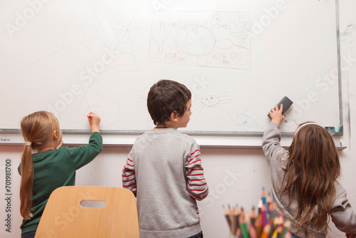 children drawing on a white board