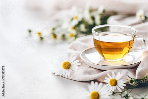 Close-up view of chamomile tea on a white table. A delicious and soothing herbal tonic with chamomile flowers, honey, and lemon, known for its immunity-boosting properties. Ample room for text.