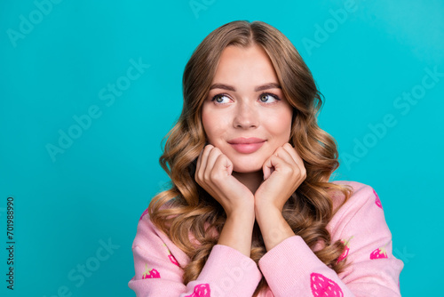 Photo portrait of young girlish model wear pink trendy jumper touch cheeks looking novelty daydreaming isolated on blue color background