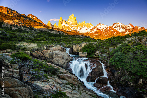 Fitz Roy Mountain in the background with a beautiful waterfall in the foreground during sunrise, near El Chalten, Patagonia, Argentina photo