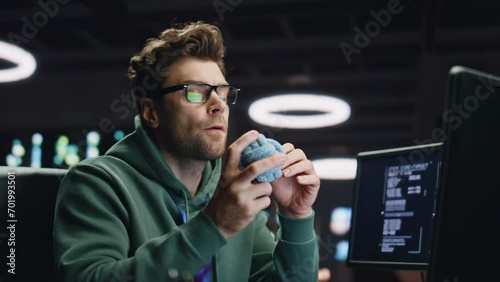 Thoughtful man looking computer pondering project at dark datacenter closeup photo