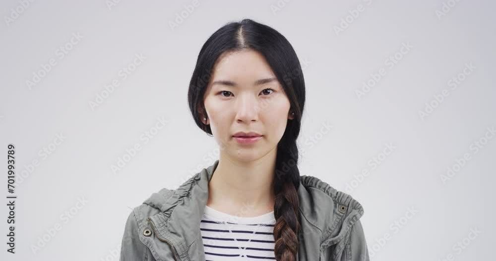 Serious asian woman, face and blank stare standing isolated against a studio background. Portrait of attractive Japanese female person or casual model looking with no expression on mockup space