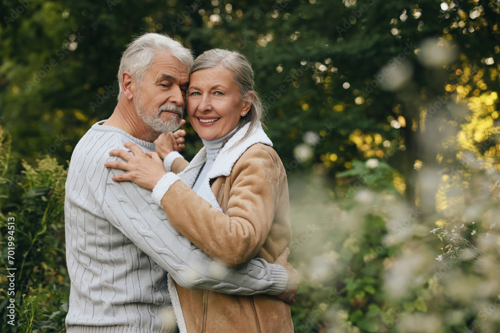 Fototapeta premium Affectionate senior couple dancing together outdoors, space for text