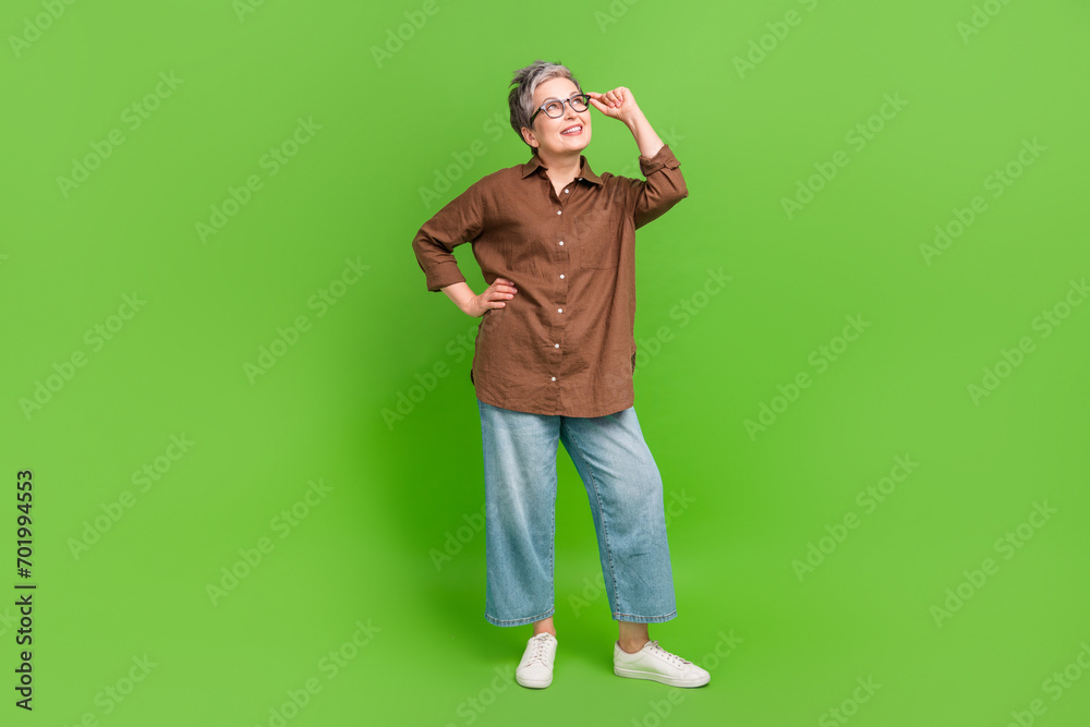 Full size photo of optimistic person dressed stylish shirt touch eyewear look at offer empty space isolated on green color background Full size photo of optimistic person dressed stylish shirt touch eyewear look at offer empty space isolated on green color background