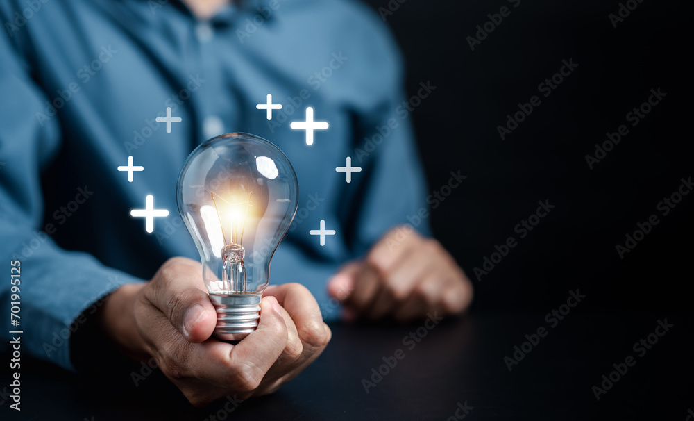 Hand man holding light bulb with plus sign, idea, innovation and ...