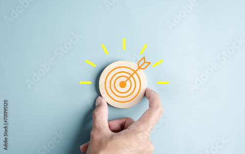 Hand holding to target objective with idea creative light bulb icon. planning development leadership and customer target group concept.