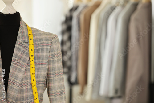 Mannequin with jacket and measuring tape in tailor shop, space for text