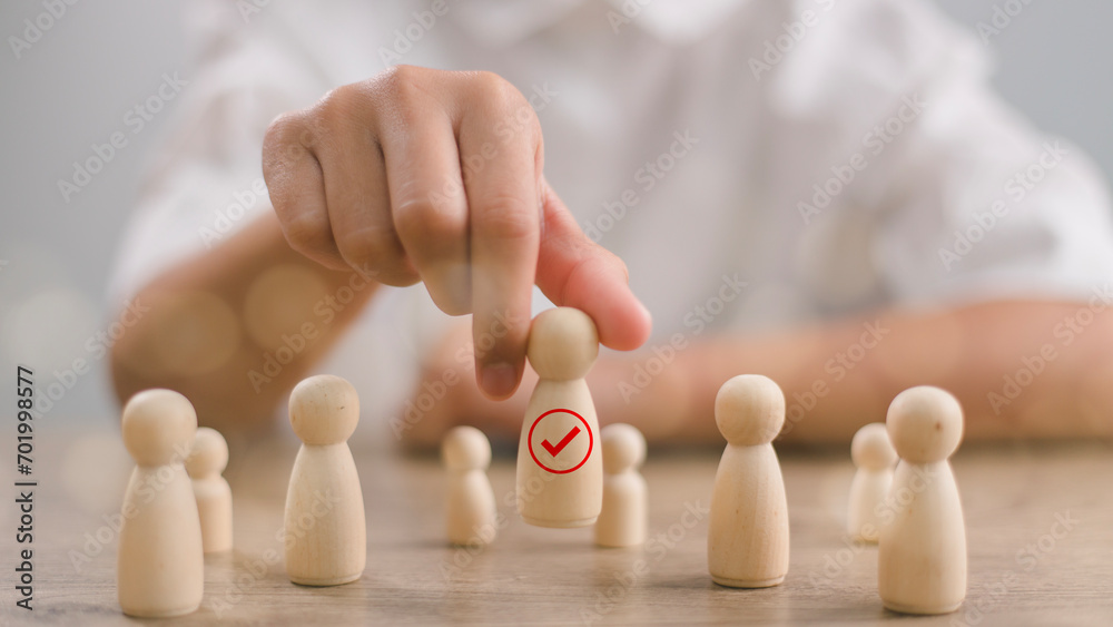 HR manager (human resources) or Employer hand choose takes person wooden doll wite face smile. Leader stands out from crowd. Looking for good worker. HR, HRM, HRD concepts.