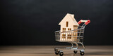A house in a shopping cart on wooden and black background with copy space. Concept of buying real estate