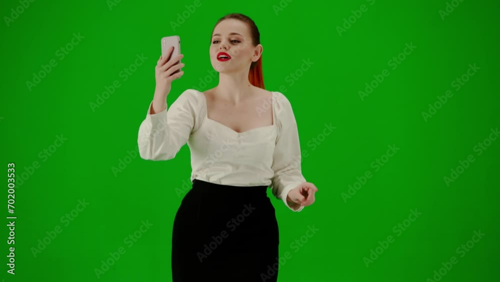 Portrait of attractive office girl on chroma key green screen. Woman in skirt walking talking on smartphone by video call, happy expression. Portrait of attractive office girl on chroma key green screen. Woman in skirt walking talking on smartphone by video call, happy expression.