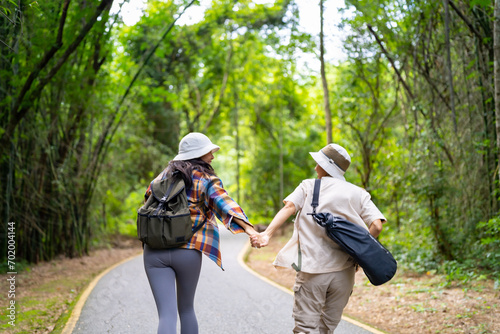 Happy LGBTQ person enjoy and fun outdoor lifestyle travel forest mountain on summer holiday vacation. Asian lesbian couple hiking and playing together in the jungle with looking beautiful nature. photo