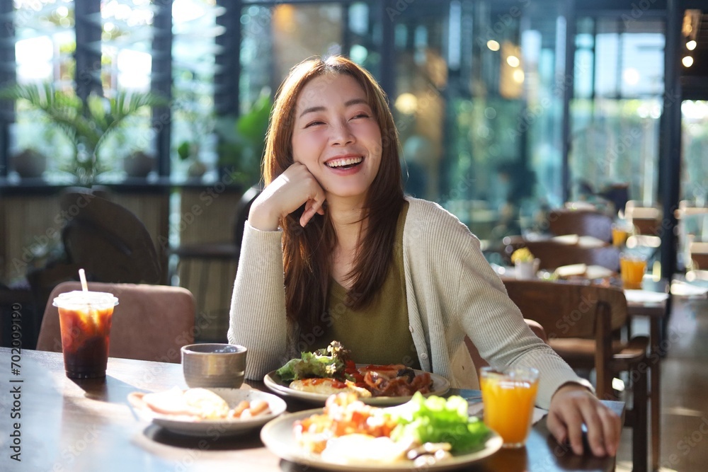 Beautiful woman joyful eating a meal in restaurant.