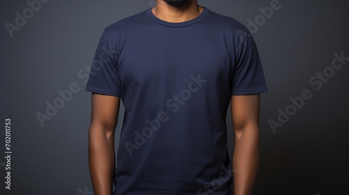 A man wearing navy blue t shirt with half sleeves over dark background 