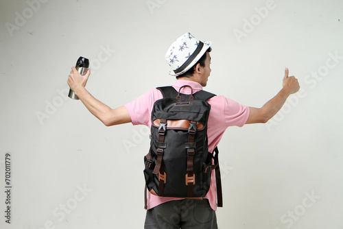 attractive asian man backpacker backpose holding tumbler bottle. travelling concept. on isolated background photo