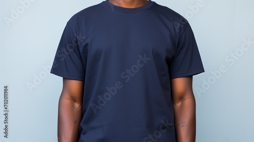 A navy blue tshirt on a person over lite blue background photo