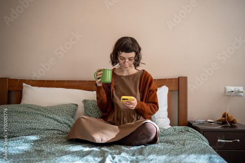 Teenage girl having social difficulties, problems in communication with agemates, spending sunny weekends at home, scrolling photos in social networks, reading news online. Addiction to mobile phone photo