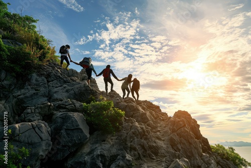 A group of family members extending helping hands to one another as they navigate a rocky ascent, a symbol of their collective resilience and commitment to shared success. photo