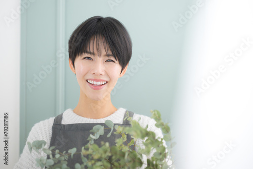 花瓶を持つ花屋のショップ販売員や家庭菜園の女性のイメージ カメラ目線の笑顔 クローズアップ