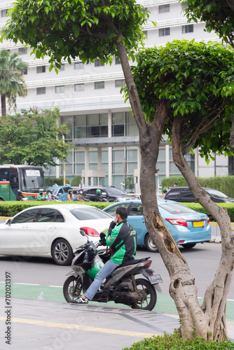 The area around Bundaran HI in Jakarta experiences high density, with public transportation, street vendors, and workers passing through, Jakarta, Indonesia, January 12nd 2022 photo