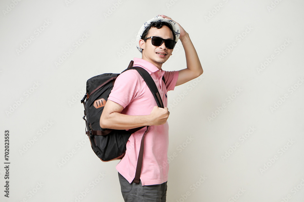 Asian man backpacker wearing sunglasses and hat. digital nomad and travelling concept. on isolated background Asian man backpacker wearing sunglasses and hat. digital nomad and travelling concept. on isolated background