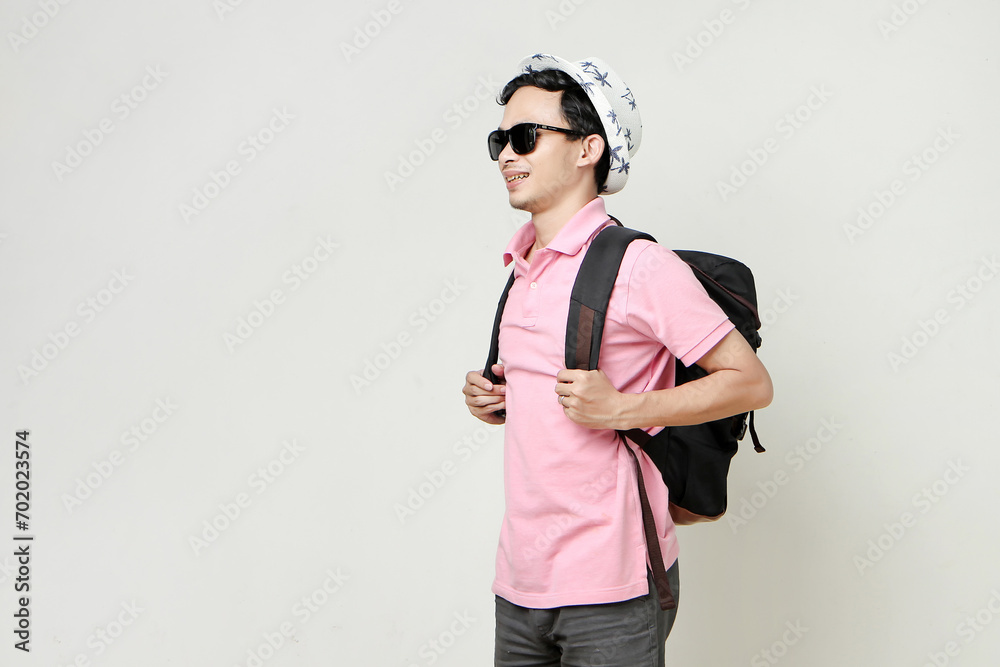 Asian man backpacker wearing sunglasses and hat. digital nomad and travelling concept. on isolated background Asian man backpacker wearing sunglasses and hat. digital nomad and travelling concept. on isolated background