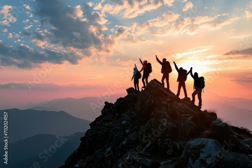 A silhouette of a family team reaching the mountain summit together, their joined hands raised in a victorious gesture, embodying the spirit of unity and shared success. photo
