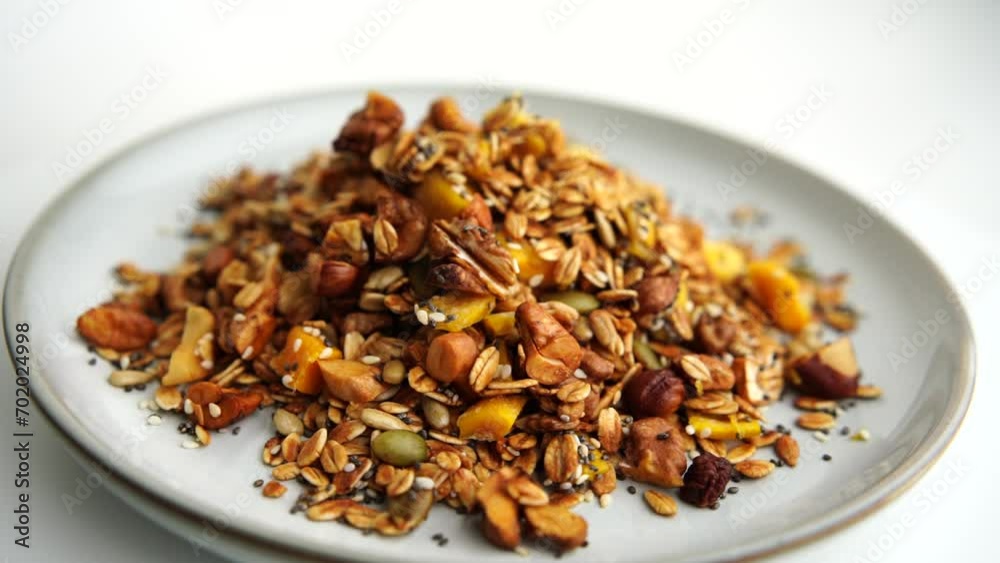 Healthy organic granola breakfast flakes with almonds, cashew nuts walnuts, hazelnuts, pumpkin seeds and cranberries circle rotation close up top view. Healthy organic granola breakfast flakes with almonds, cashew nuts walnuts, hazelnuts, pumpkin seeds and cranberries circle rotation close up top view.