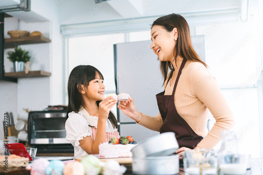 Happy asian family mother and daughter cooking in kitchen bake cake at home Happy asian family mother and daughter cooking in kitchen bake cake at home