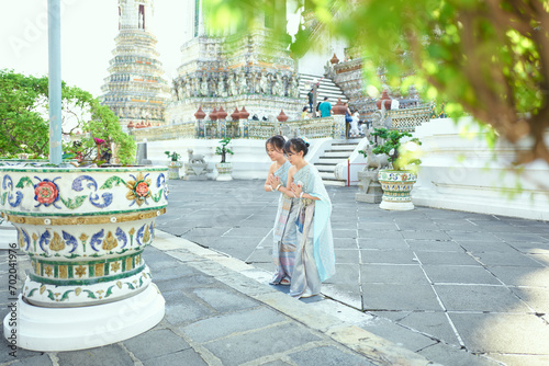 Asian sister wearing Thai traditional clothes dancing at Wat Arun photo