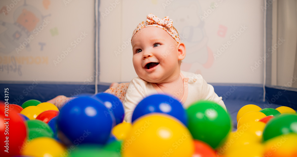 Cute baby girl playing with colorful balls in kindergarten. Cute baby girl playing with colorful balls in kindergarten.