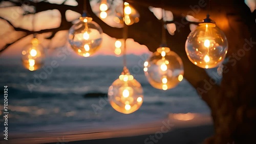 Small glass orbs, adorned with ling fairy lights, hang from tree branches and illuminate the beach with a magical glow. The contrast between the dark sky and the bright lights is enchanting.