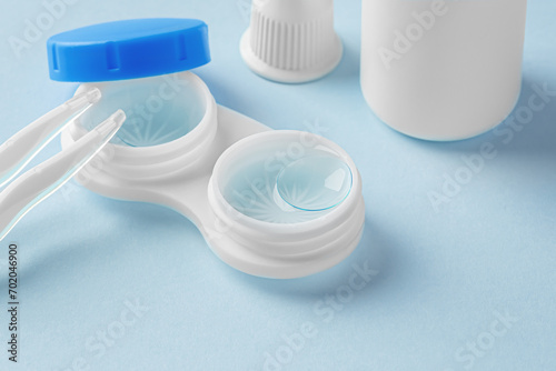 Contact lenses in case with solution liquid on blue background, cleaning contact lens concept