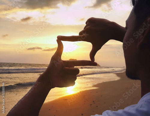 Close up of tourist  hands making frame gesture on the sea beach with sunse © New2023