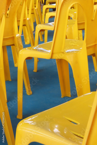 Yellow plastic chairs set up in school gymnasium, Bangkok, Thailand. © Amazingness