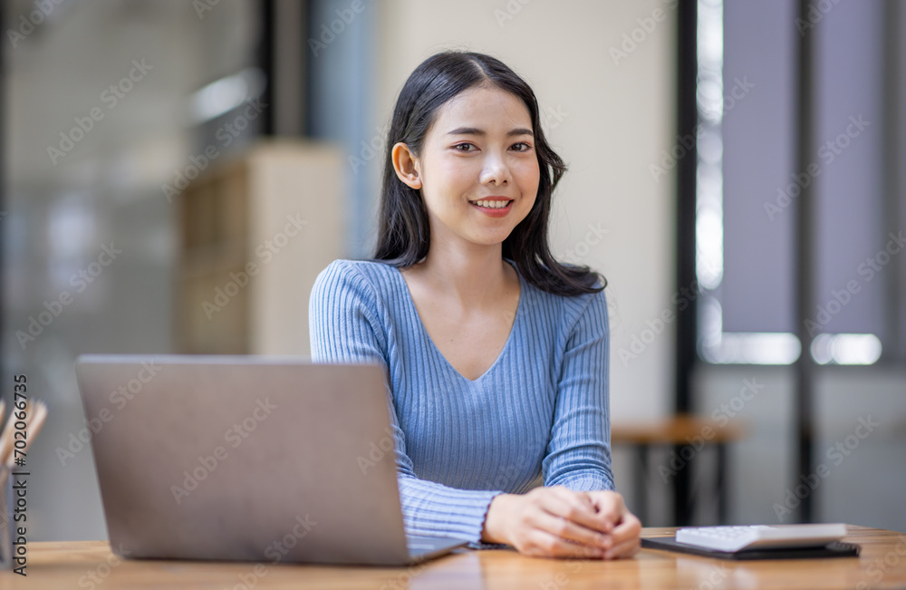 Asian Business woman using calculator and laptop for doing math finance on an office desk, tax, report, accounting, statistics, and analytical research concept Asian Business woman using calculator and laptop for doing math finance on an office desk, tax, report, accounting, statistics, and analytical research concept
