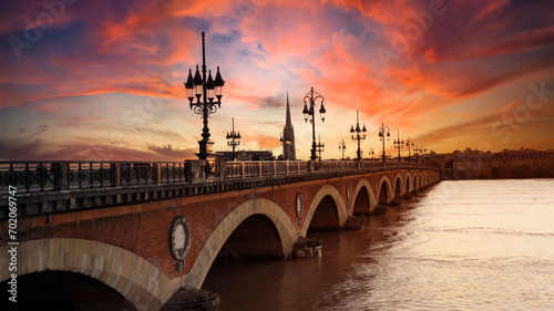 Fotografie View of the Pont de pierre with sunset sky scene which The Pont de pierre crossing Garonne river ,Bordeaux ,France