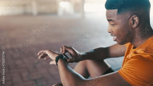 Black man, fitness and breathing, relax after running outdoor and check progress on watch for health and wellness. Cardio, training and recover from workout, results and heart rate with exercise