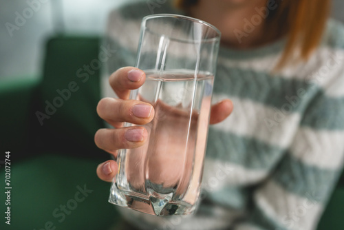 close up on midsection of unknown caucasian woman hold glass of water