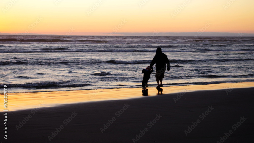 Father and son at sunset on beach