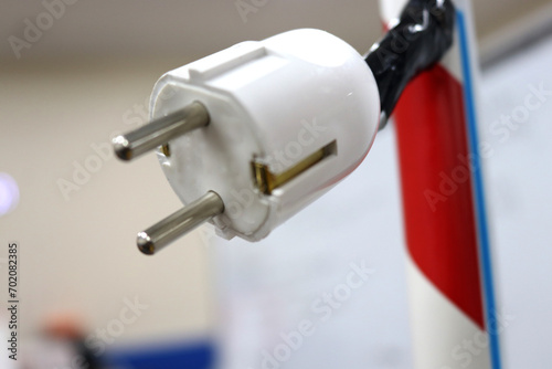 Photo of an electric plug, Plug or Staker or what is sometimes often called an electric plug, because it is in the form of two metal plugs and is an electrical device whose function is to connect 