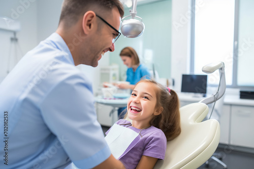 Smiling pediatric dentist with a young patient in dental clinic, Professional stomatology for kid.