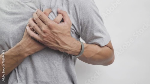 Young man with heart disease, holding hands on chest. Heart attack or stroke. risk of coronary heart disease, diabetes, hyperlipidemia, high blood pressure. isolated.