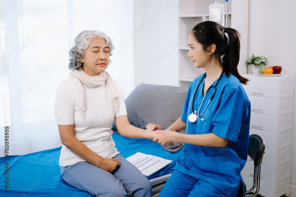 Fototapeta premium Doctor in white suit take notes while discussing and Asian elderly, woman patient who lying on bed with receiving saline solution